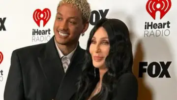 Cher i jej młodszy partner pozują na ściance iHeartRadio.
