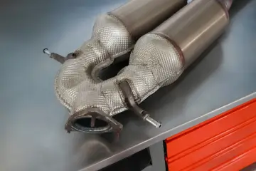 Element układu wydechowego, prawdopodobnie DPF, na metalowym blacie. Zastanawiasz się, ile kosztuje dpf na złomie?