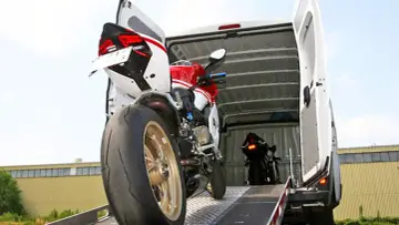 Dwa sportowe motocykle ładowane do furgonetki. Jeden czerwono-biały, drugi czarny. Idealne dla miłośników niemieckich stron z motocyklami.