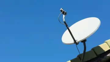Antena satelitarna na dachu, gotowa do ustawiania sygnału.