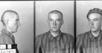 Trzech więźniów obozu Auschwitz, w tym jeden z tabliczką "Pol. 31", w pasiastych ubraniach. Jeden z nich, jakby zapamiętał historie, które chciałby opowiedzieć jako pisarz.