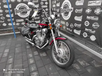 Czarny motocykl Lifan 250 z czerwonymi akcentami i sakwami, gotowy na przygodę.