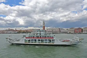 Traghetto ACTV che naviga sul Canal Grande, con lo sfondo di Venezia e il Palazzo Ducale.
