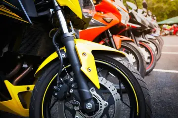 Una fila di moto sportive, tra cui una Yamaha scarenata gialla in primo piano, pronte per la corsa.