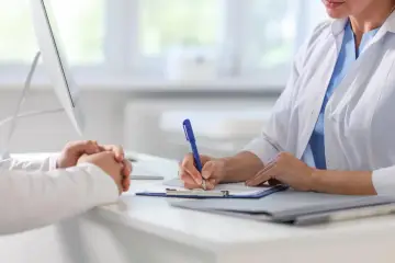 Lekarz notuje informacje o pacjencie, który rozważa ile L4 po laserowej korekcji wzroku.
