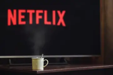 Gorąca herbata i seans na Netflix NW-2-5. Para unosi się z kubka na tle ekranu z logo.