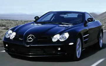 Czarny SLR McLaren pędzi po pustynnej drodze, jego sylwetka lśni w słońcu.
