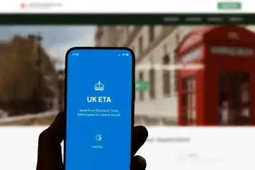 Dłoń trzyma smartfon z aplikacją UK ETA, która ułatwia uzyskanie zezwolenia na podróż do Wielkiej Brytanii.