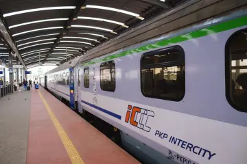 Pociąg PKP Intercity na peronie, z widocznymi oknami i logo.