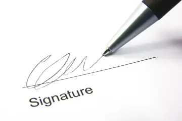 A pen signs a document, finalizing a corporate sponsorship agreement.
