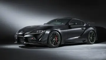 Matowa czerń podkreśla agresywną sylwetkę sportowego coupe Toyota GR Supra. Widoczne czerwone zaciski hamulcowe i aerodynamiczne dodatki.