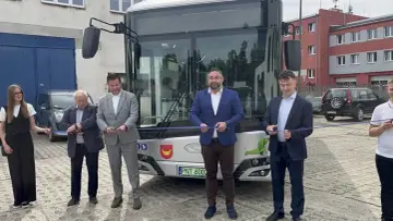 Uroczyste przecięcie wstęgi przed nowym autobusem, symbolizującym rozwój komunikacji miejskiej w Nowym Tomyślu.