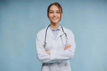Uśmiechnięta lekarka w białym kitlu ze stetoskopem, zastanawia się, ile zarabia psychiatra.