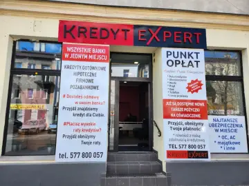 Elewacja biura "Kredyt Expert" z banerami informującymi o ofertach kredytowych i punktem opłat.