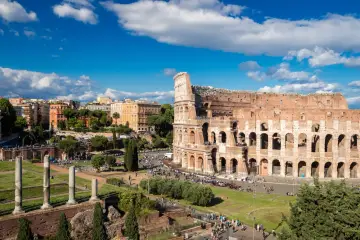 Koloseum w Rzymie, z turystami i budynkami w tle. Czy Roma Pass się opłaca?