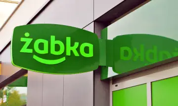 Zielony szyld Żabki. Zastanawiasz się, ile zarabia 16 latek w Żabce miesięcznie? To pytanie nurtuje wielu młodych ludzi.