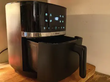 Czarny air fryer Bosch z wysuniętą szufladą. Dowiedz się, jak usunąć zapach spalenizny z air fryera po pierwszym użyciu.