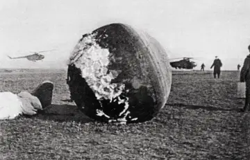 Kapsuła po pierwszym locie w kosmos. W tle lądujące helikoptery i ludzie.