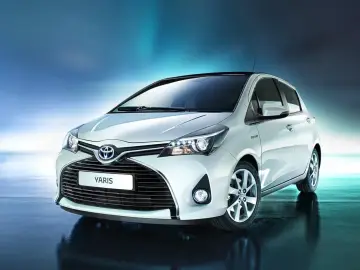Biały Toyota Yaris, znany też jako Vitz, prezentuje się elegancko na tle błękitnego gradientu.
