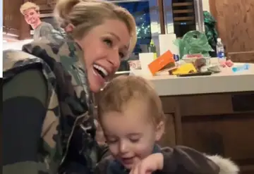 Paris Hilton z dziećmi, śmieje się radośnie, podczas gdy jej syn bawi się na stole.
