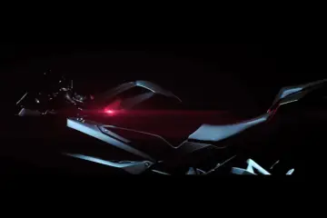 Ciemny motocykl sportowy Honda CBR 250RR z czerwonym akcentem świetlnym.