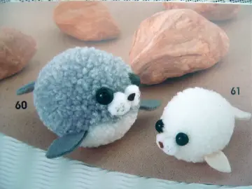 Urocze, puszyste foki z modeliny kawaii. Dwie słodkie figurki, szara i biała, zachęcają do zabawy i tworzenia własnych zwierzątek.