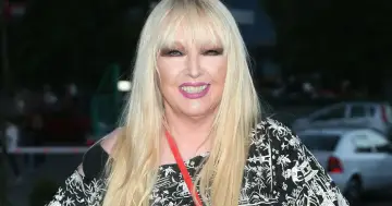 Uśmiechnięta Maryla Rodowicz, której wiek nie przeszkadza w byciu ikoną stylu, w czarno-białej bluzce z ozdobnym wzorem.