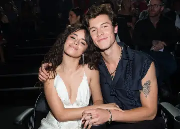 Camila Cabello i Shawn Mendes siedzą blisko siebie, uśmiechając się do aparatu.
