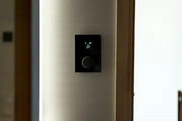 Nowoczesny panel sterowania ogrzewaniem domu pokazuje 27 stopni.