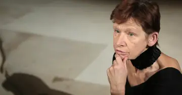 Jadwiga Jankowska Cieślak zamyślona, z dłonią podpartą na brodzie.