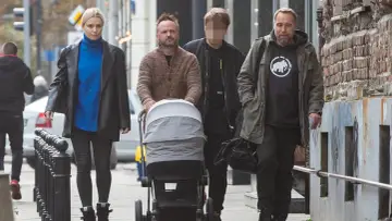 Marcin Kindla z rodziną spaceruje z wózkiem. Dzieci są w wózku, a dorośli idą obok.