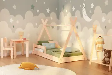 Pokój dziecięcy w stylu Montessori: łóżko tipi, stolik z krzesełkiem, pluszaki i dekoracje z chmurkami i gwiazdkami.
