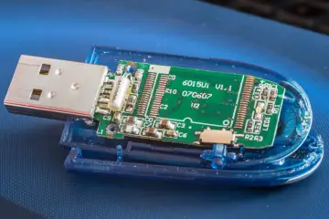 Rozłożony pendrive z widoczną zieloną płytką drukowaną, złączem USB i elementami elektronicznymi. Może być sformatowany w systemie FAT32.