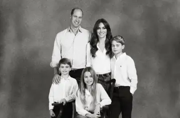 Uśmiechnięci William i Kate z dziećmi, ubranymi na biało, pozują do rodzinnego portretu.