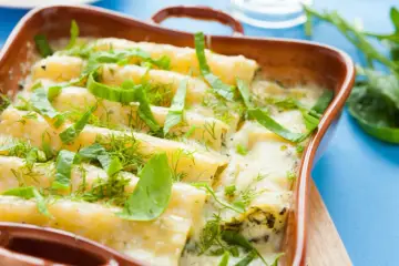 Zapiekane cannelloni w sosie śmietanowym, posypane ziołami.