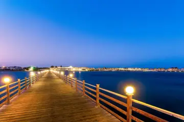 Drewniany molo oświetlone latarniami prowadzi do wybrzeża Marsa Alam. Woda jest spokojna, idealna do kąpieli, a temperatura wody w Marsa Alam jest zawsze przyjemna.