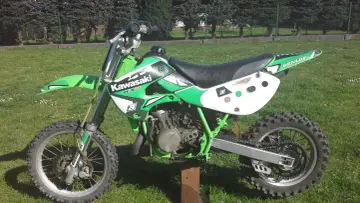 Zielony Kawasaki KX 65, idealny dla młodych adeptów motocrossu. Ile ma koni? To zależy od wersji, ale ten model to świetna zabawa!