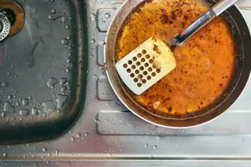 Zlepek zużytego oleju gastronomicznego na patelni obok zlewu.