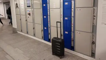 Przechowalnia bagażu Warszawa Centralna. Czarna walizka czeka przed rzędem szafek.