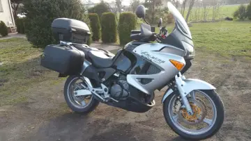 Srebrno-czarny motocykl Honda Varadero 1000 z kuframi, gotowy na podróż. Dane techniczne tego modelu są imponujące.