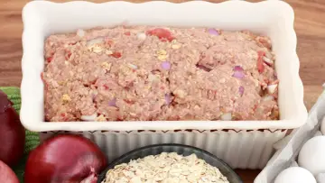Masa na tradycyjny klops w naczyniu, obok cebula, płatki owsiane i jajka.
