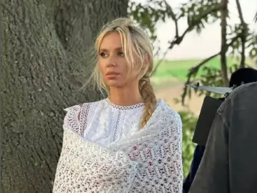 Kasia Moś w białej koronkowej sukience i narzutce, z warkoczem. Ile lat ma Kasia Moś?