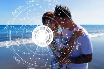 Para zakochanych na plaży, otoczona kołem zodiaku. Ich miłość jest jak numerologiczna 4 – stabilna i pełna harmonii.