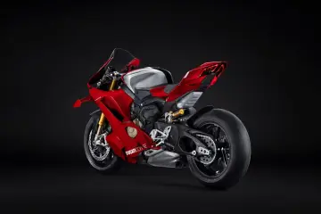 Czerwony motocykl Ducati V4R z błyszczącym, srebrnym bakiem paliwa, prezentujący swoje sportowe linie na czarnym tle.