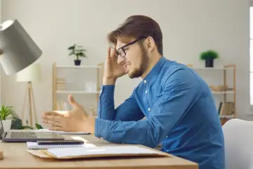 Frustracja mężczyzny przy biurku. System Windows zatrzymał to urządzenie z powodu zaraportowanych problemów (kod 43).