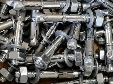 Mnóstwo metalowych kołków rozporowych, gotowych do użycia jako kotwa chemiczna epoksydowa.