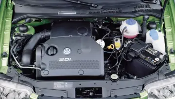 Silnik SDI Volkswagena, gotowy do pracy. Obok akumulator i płyny eksploatacyjne.