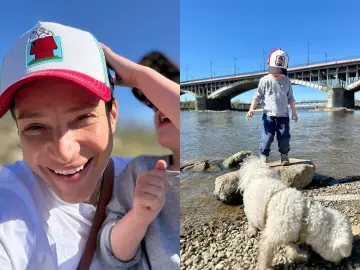 Uśmiechnięta Lena Grabowska z dzieckiem i psem nad rzeką. Wiek nie gra roli w dobrej zabawie.