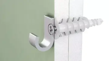 Metalowy haczyk zamocowany za pomocą kołka do płyt GK w zielonej ścianie.