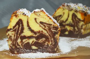 Wilgotna babka marmurkowa na oleju, z pięknymi wzorami ciasta i posypana cukrem pudrem. Idealna na deser.